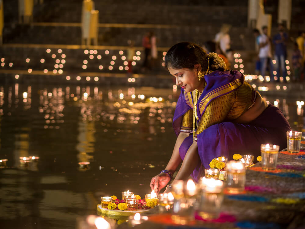 Mujer prendiendo una linterna en Diwali