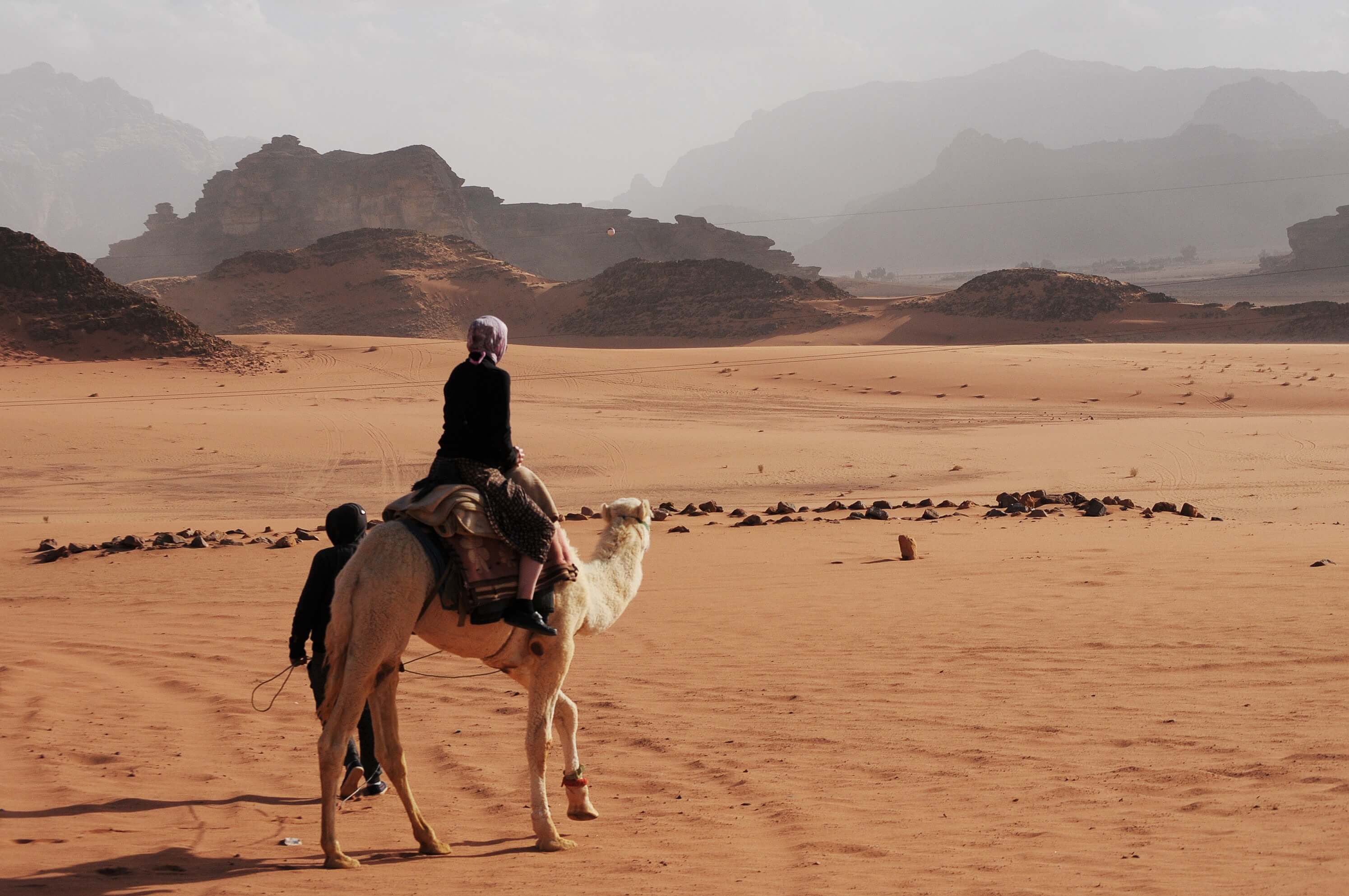 Mujer a camello por Wadi Rum
