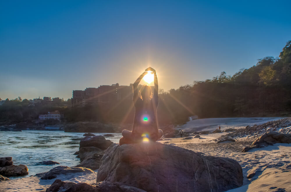 Hombre practicando yoga junto al Ganges en Rishikesh