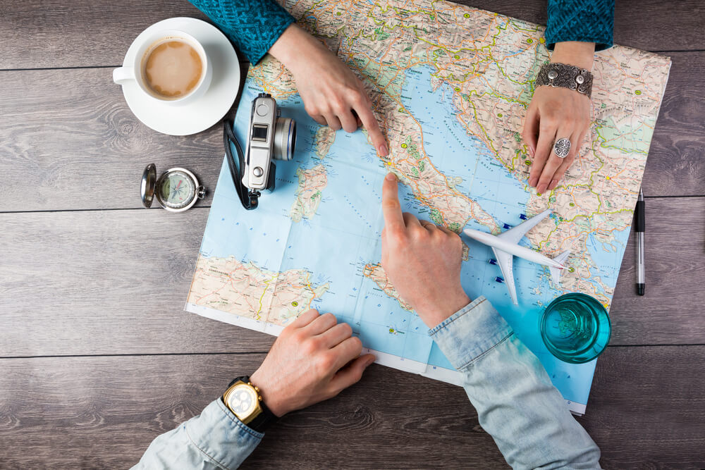 Pareja planeando el viaje de novios sobre un mapa