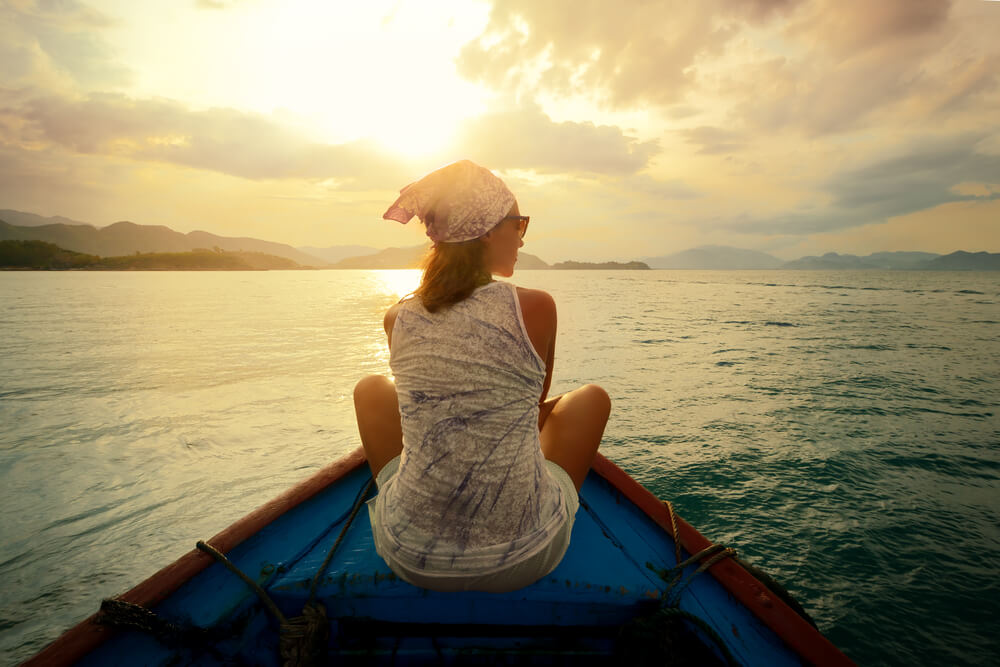 Mujer mirando el atardecer en una barca