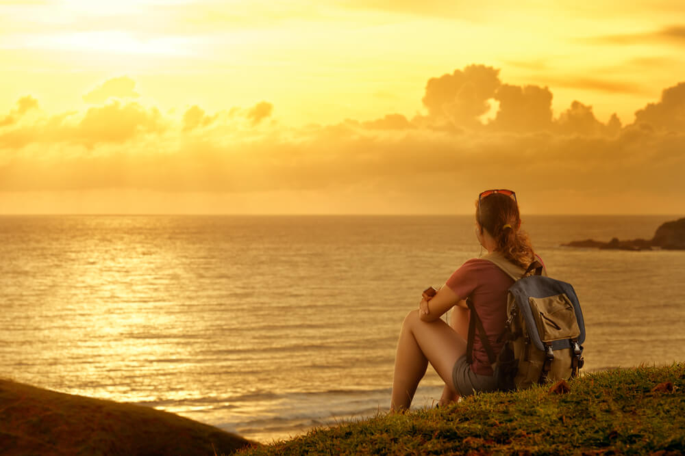 Chica mirando el paisaje al atardecer
