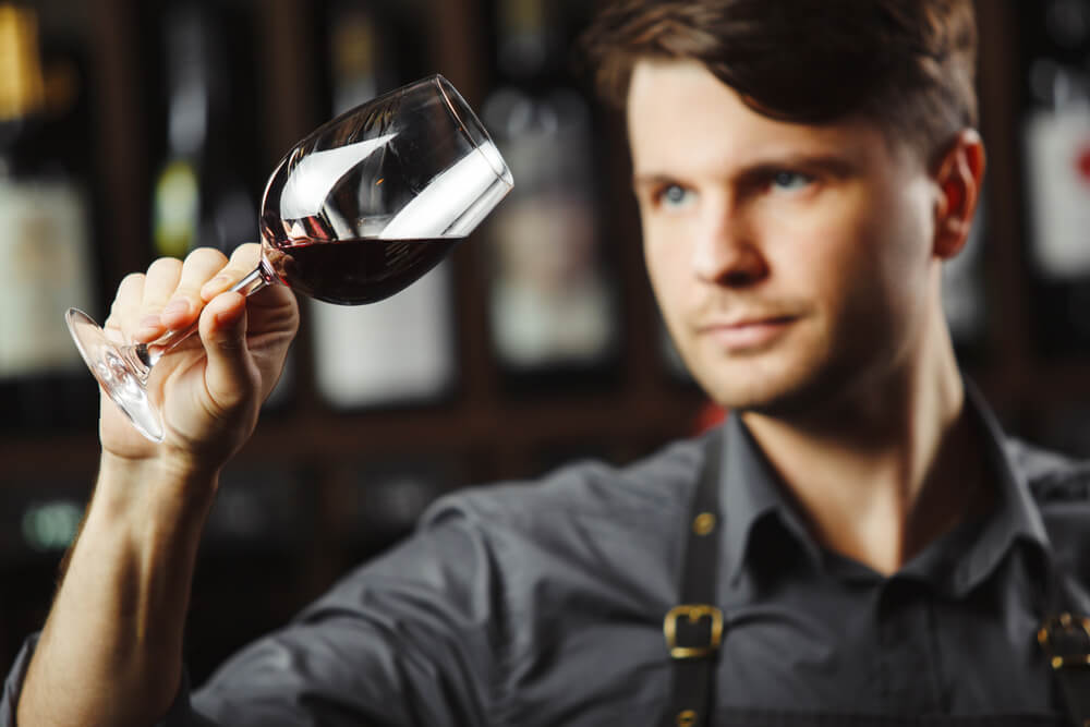 Hombre mirando una copa de vino