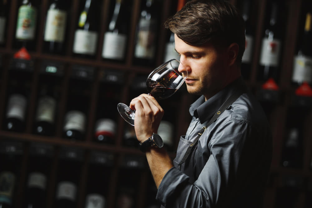 Hombre oliendo una copa de vino