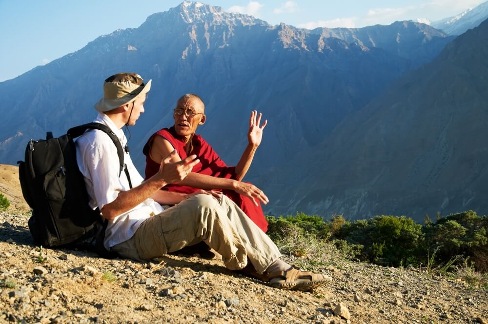 Viajero hablando con un monje en uno de los tipos de turismo