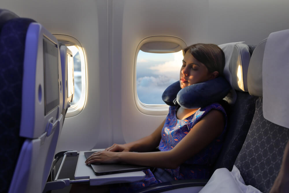 Mujer durmiendo en un avión