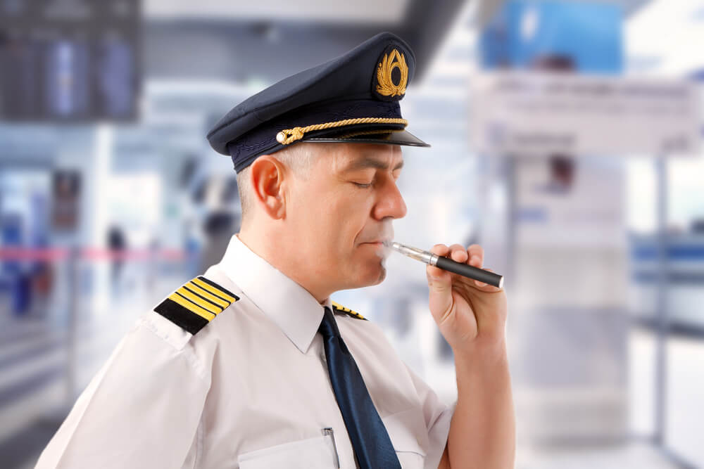 Piloto fumando un cigarro electrónico