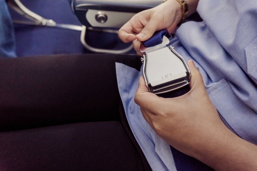 Motivos para expulsarte de un avió: mujer quitándose el cinturón