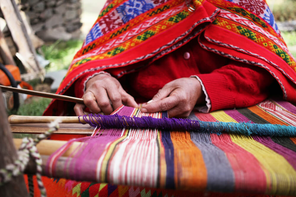 Artesanías de Perú: mujer hilando con lana de alpaca