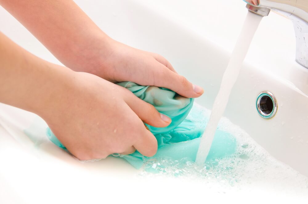 Mujer lavando ropa en el baño