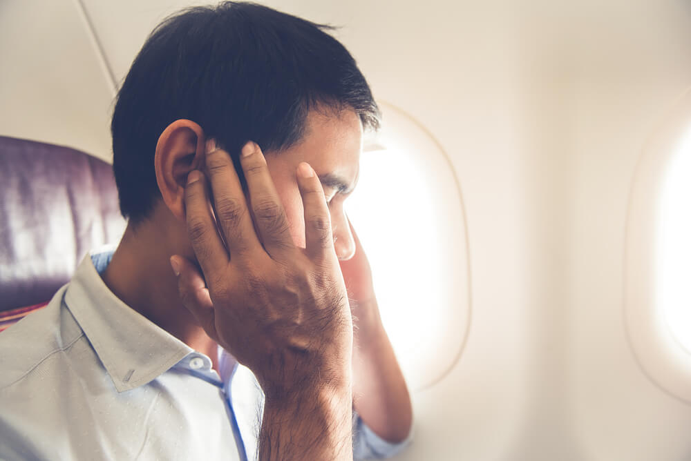 Pasajero con dolor de oídos, uno de los uno de los malestares que pueden surgir en un avión