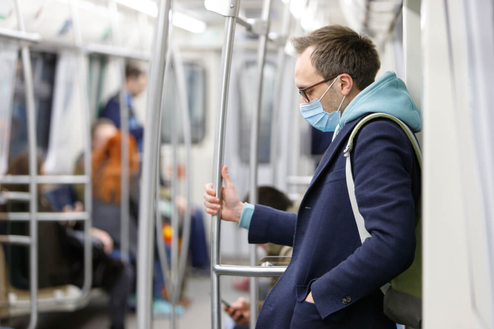 Hombre con mascarilla para protegerse de coronavirus en el transporte público