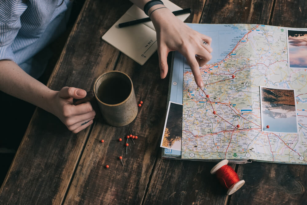 Mujer marcando una ruta en un mapa