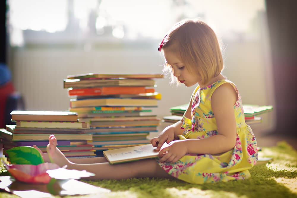 Niña leyendo en casa durante Día del Libro por el confinamiento.