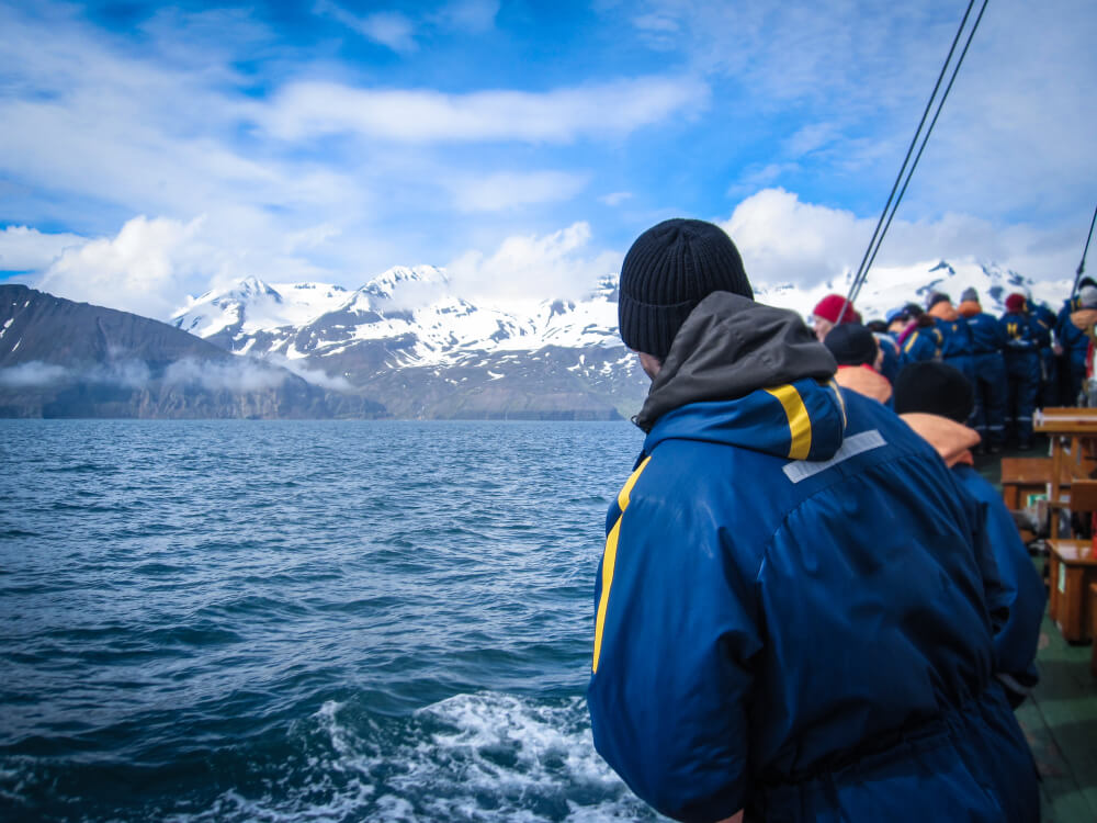 Personas en un barco para ver ballenas en Islandia.