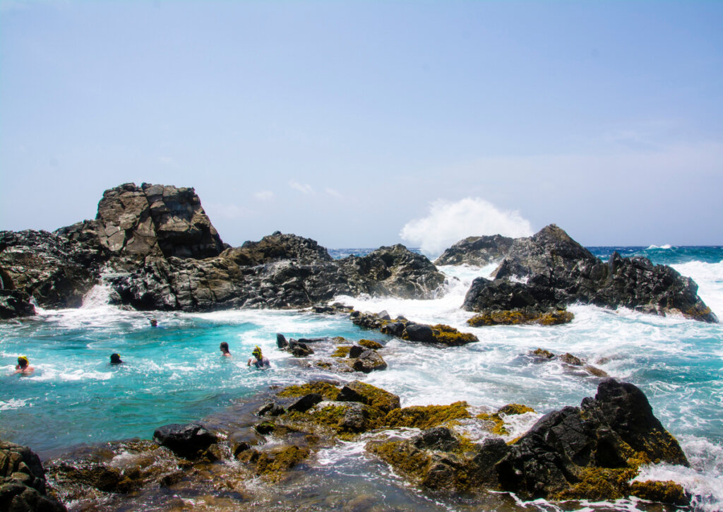Turistas disfrutando de las piscinas naturales en Aruba.