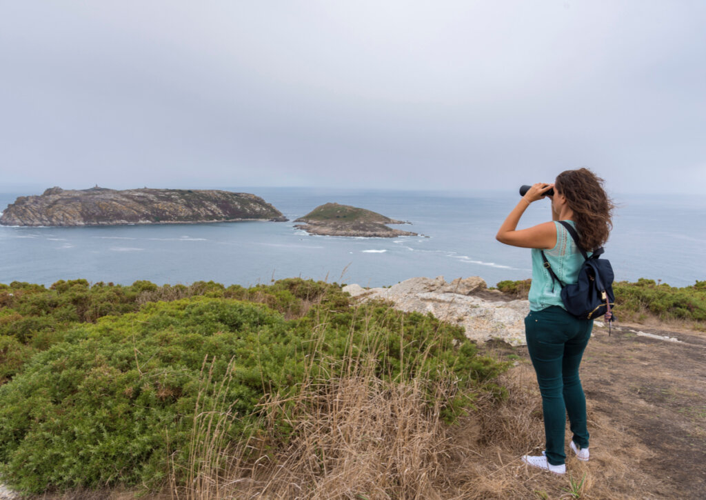 Chica observa con binoculares en las islas Sisargas.