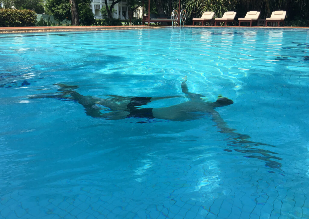 Turista haciendo natación en la piscina de un hotel.