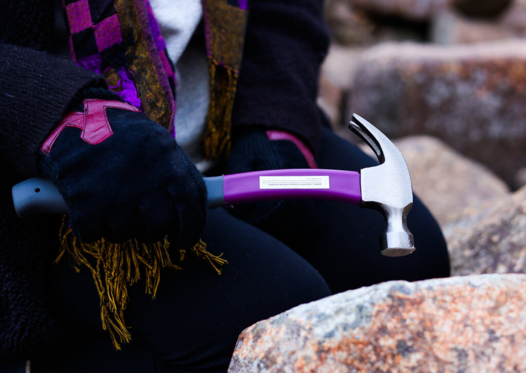 Mujer golpeando a las rocas resonantes de Pensilvania con un martillo.