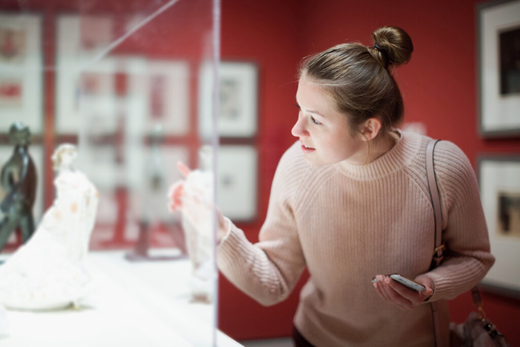 Mujer viendo obra de arte en un museo.