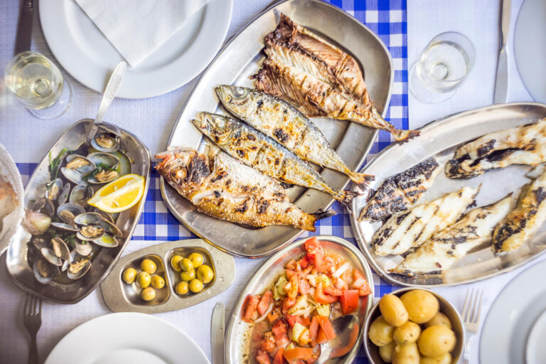 Lubina a la brasa, dorada, jurel acompañado con ensalada de tomate, almejas, pan y vino blanco.