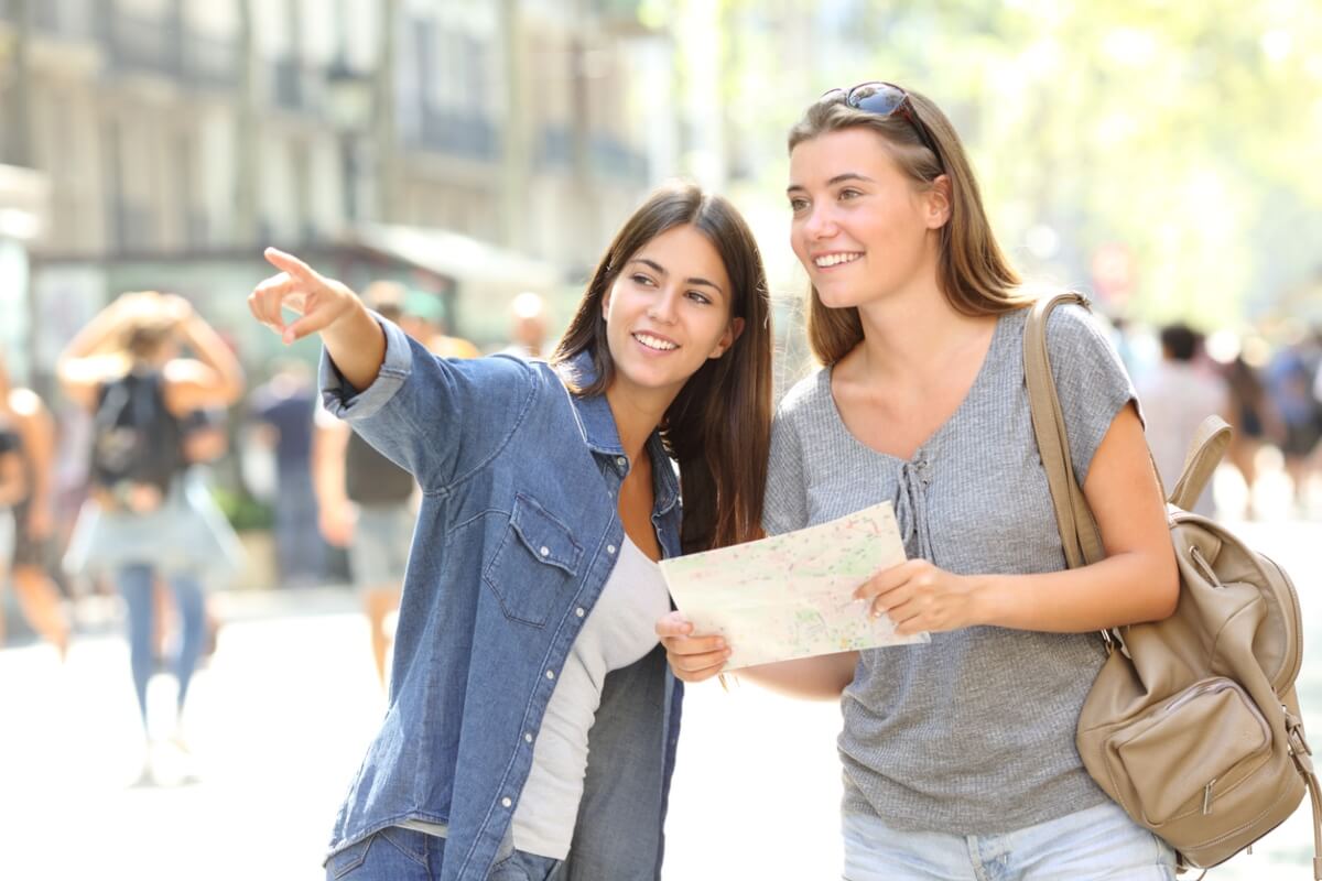 Mujer ayudando a una turista con una dirección.
