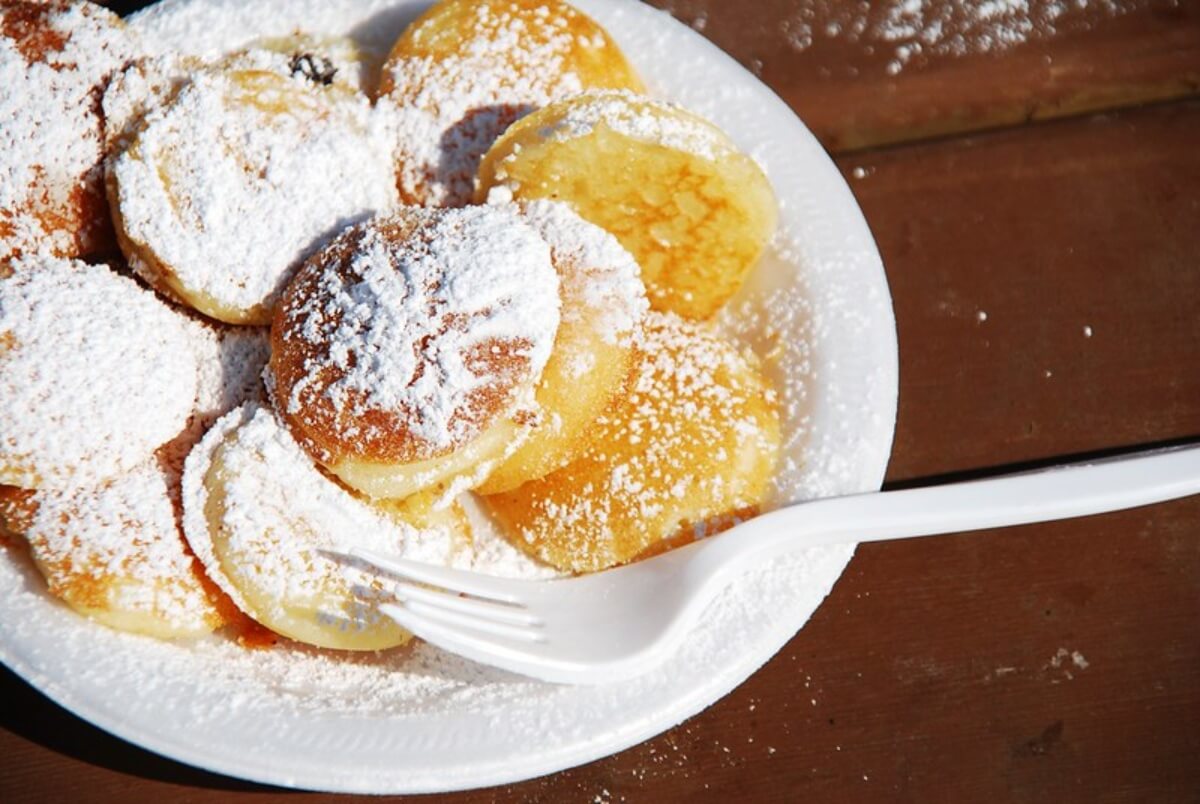 Poffertjes, comida típica en Ámsterdam, sobre un plato en una mesa.